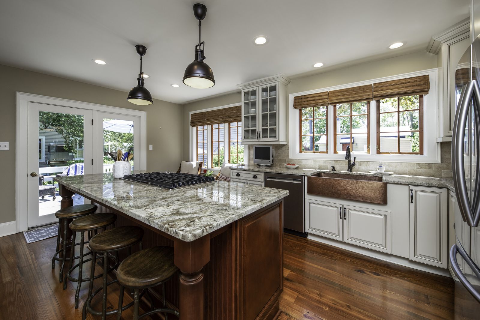 Kitchen island with granite top and stained wood cabinetry